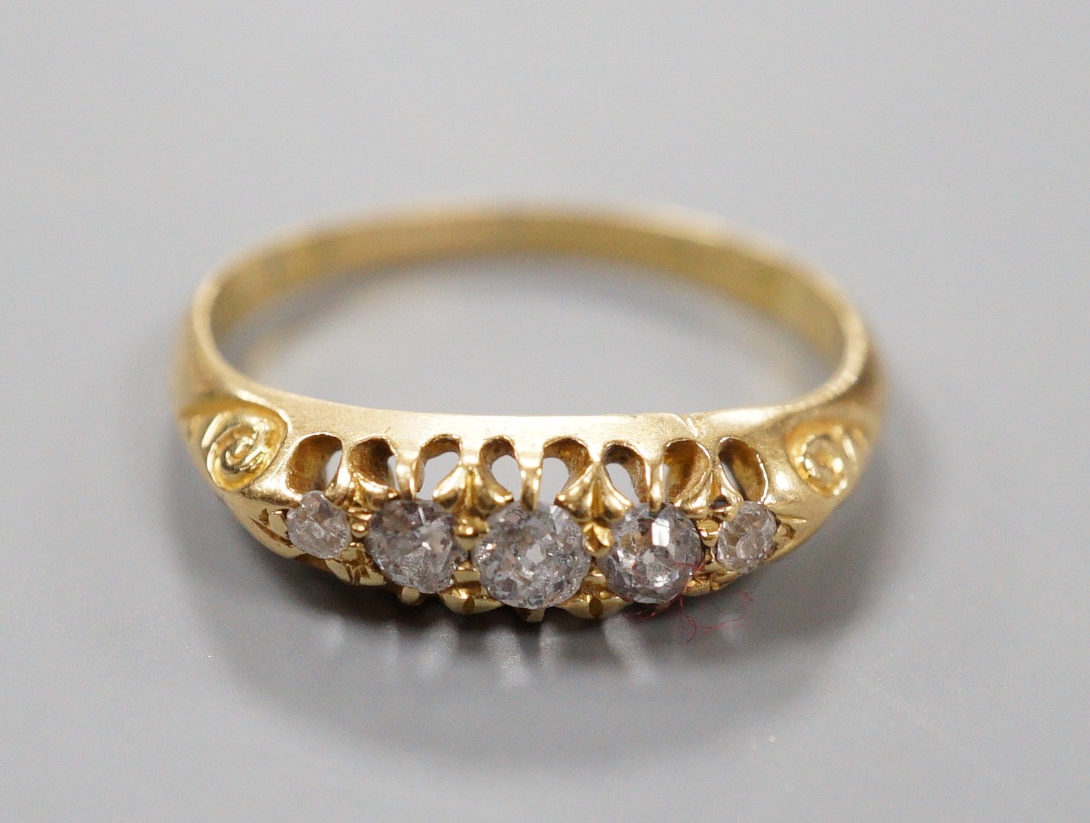 An Edwardian 18ct gold and graduated five stone diamond set half hoop ring, size M, gross weight 2.5 grams.